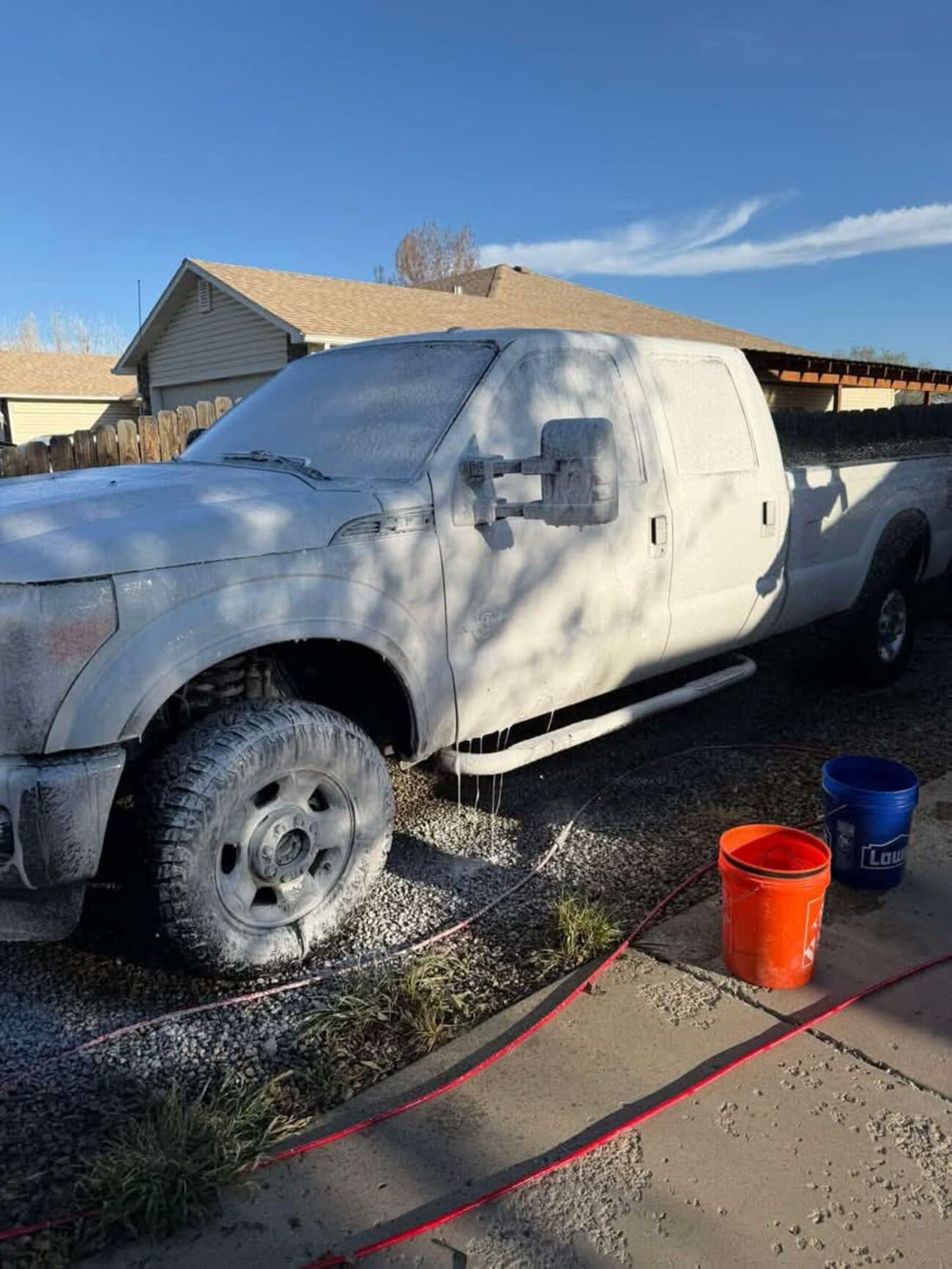 Ford F-250 covered in snow foam during a wash
